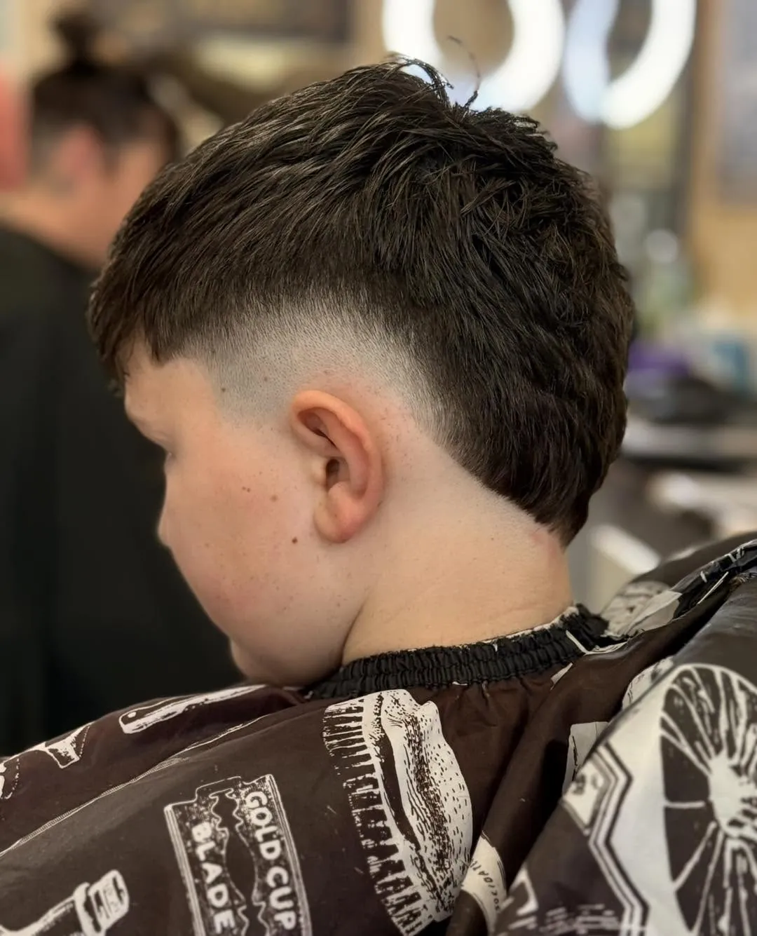 Side view of a fresh short fade at Lords Of The South: textured dark hair on top, graduating cleanly down to skin around the ear and neckline